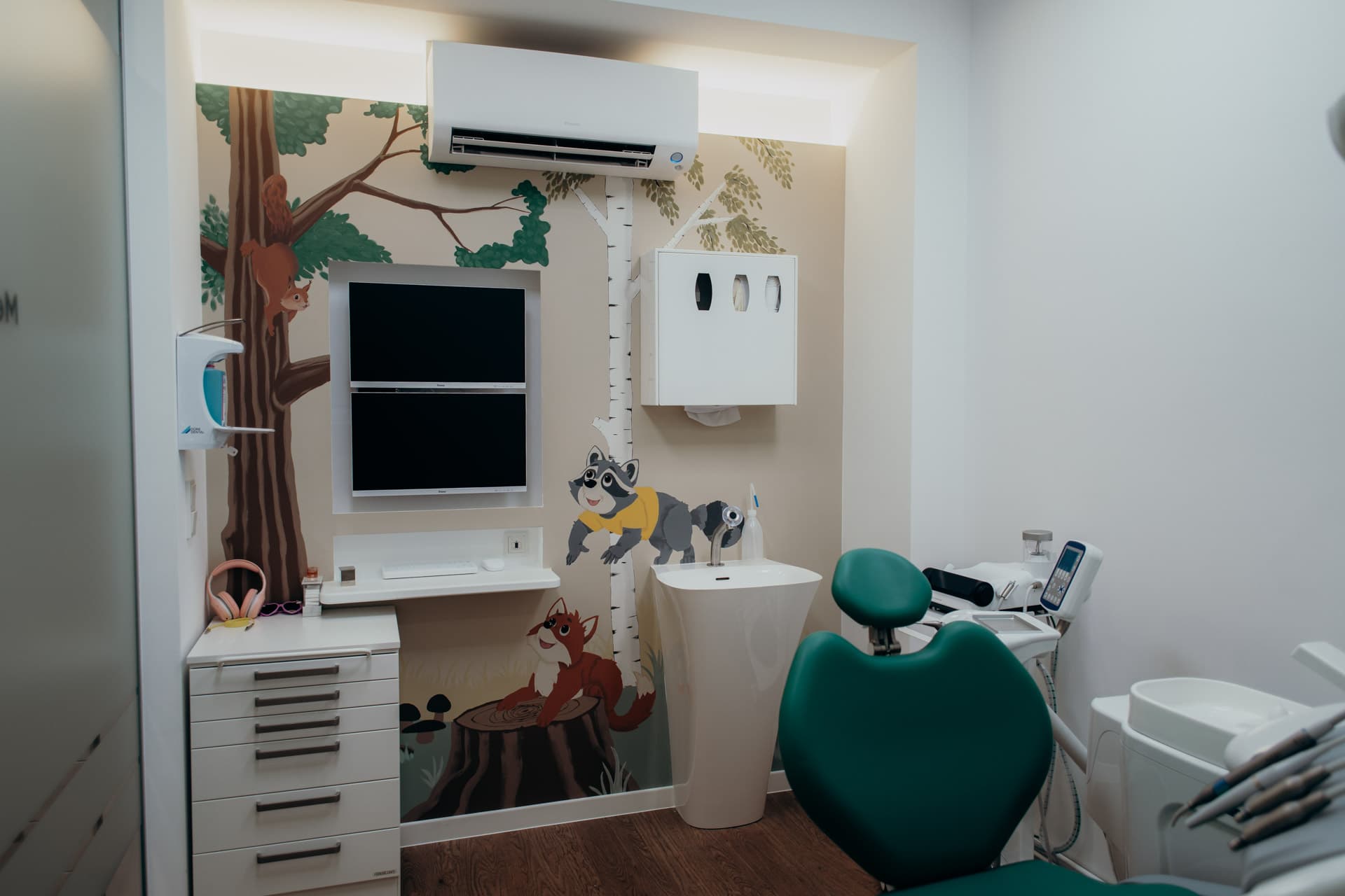 Behandlungszimmer mit Waldmotiv und Zahnarztstuhl bei kidsReinisch