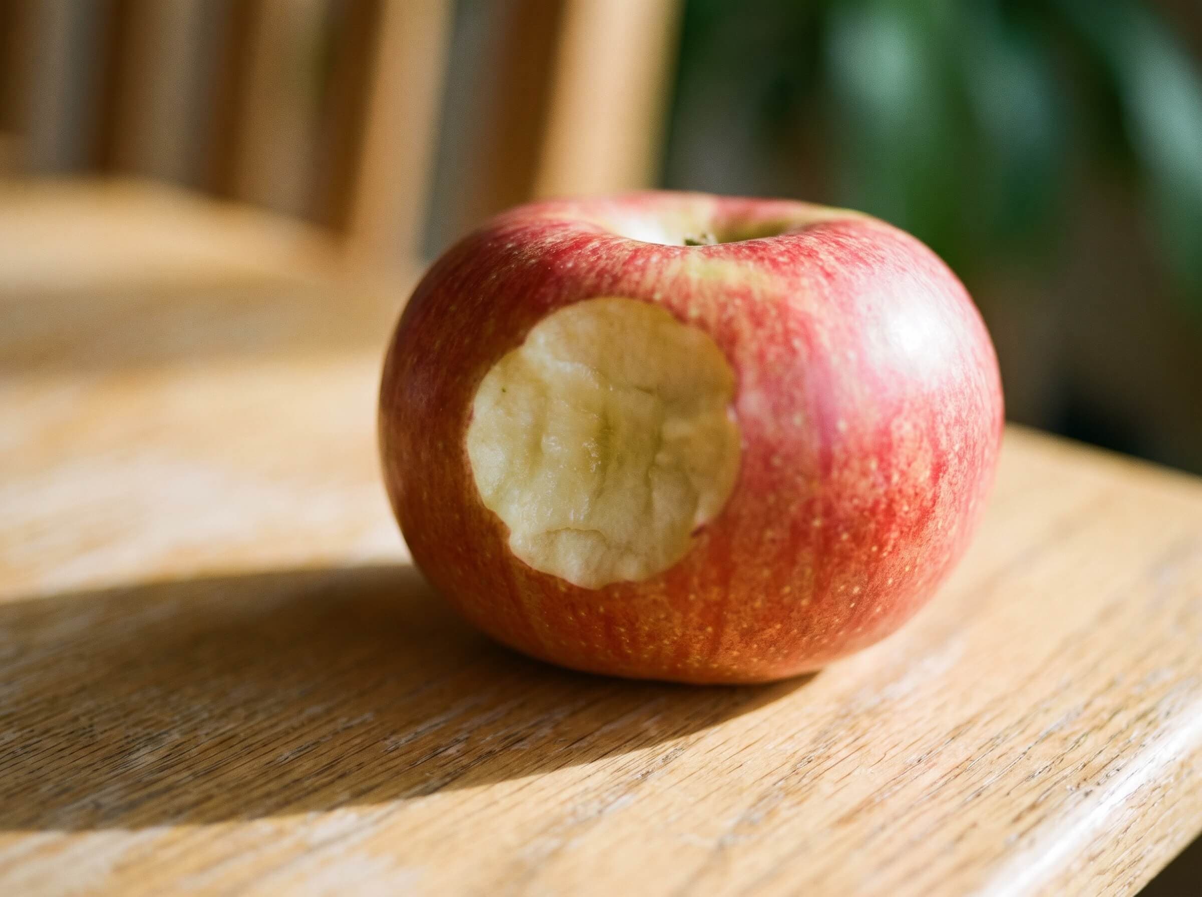 Apfel mit Biss auf dem Holztisch bei kidsReinisch